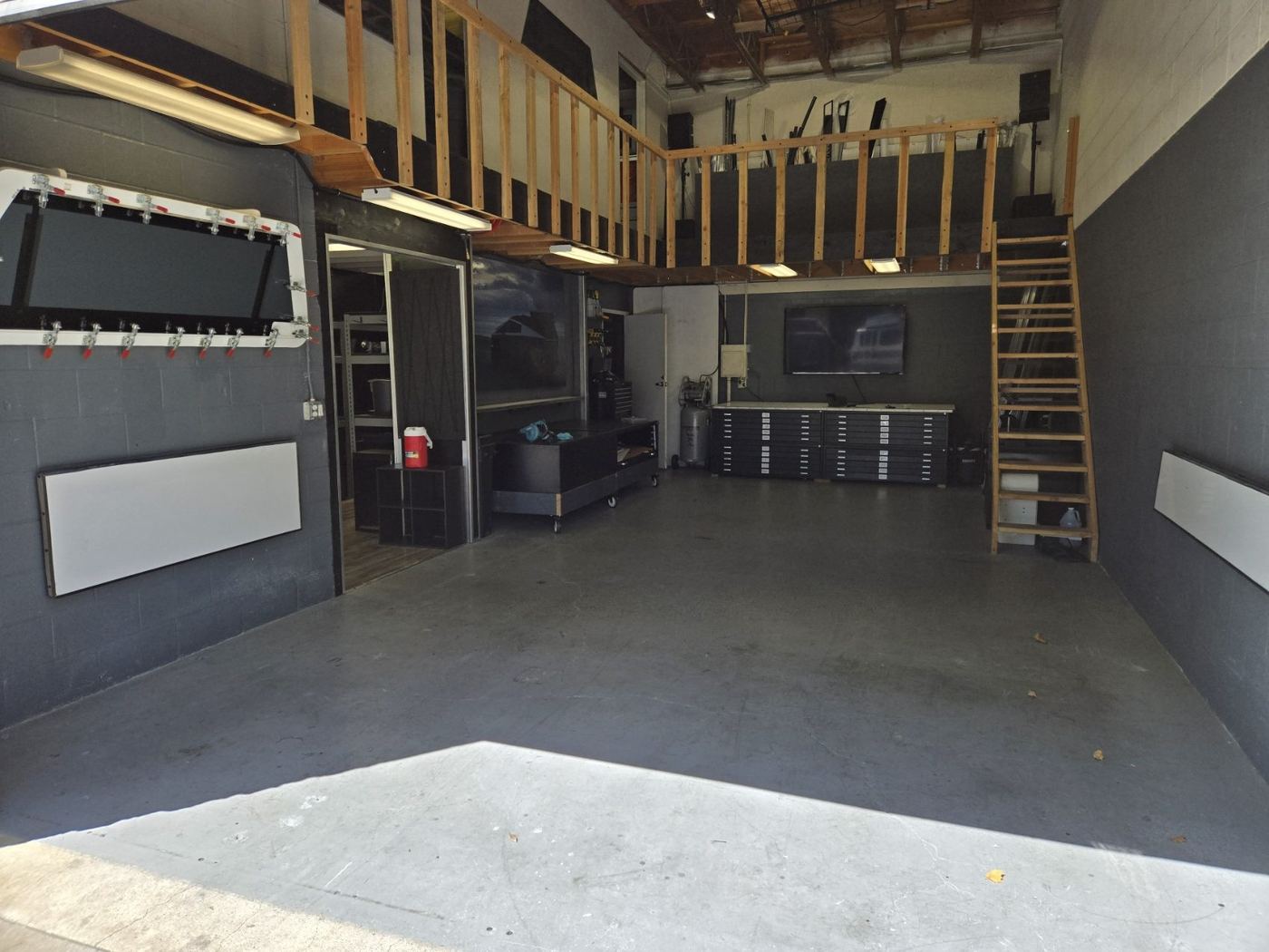 Inside Lee's Exactlee shop, with a mezzanine loft, flat file cabinets, and a composite mold fixture mounted on the wall