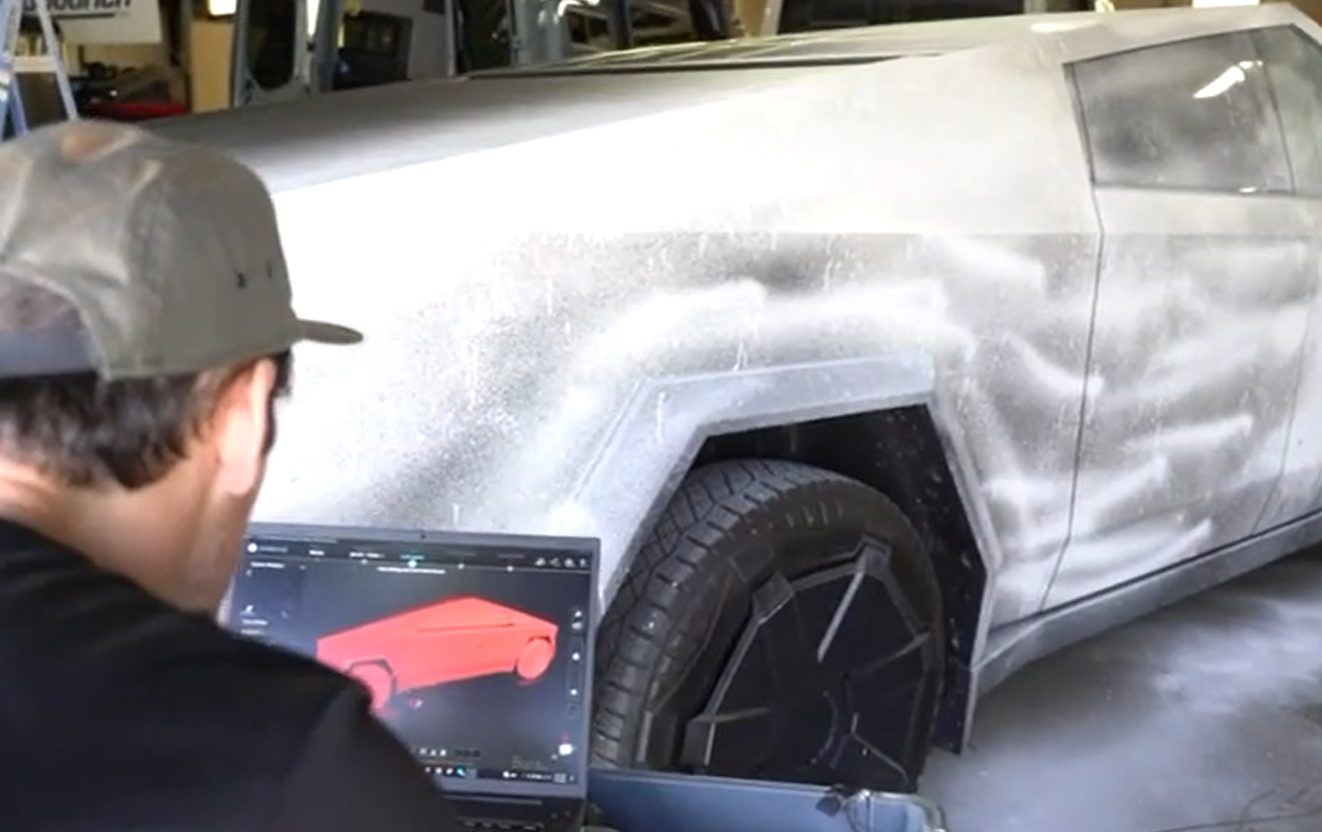 Video still comparing the scanned composite surface to a CAD model on a laptop beside the mold