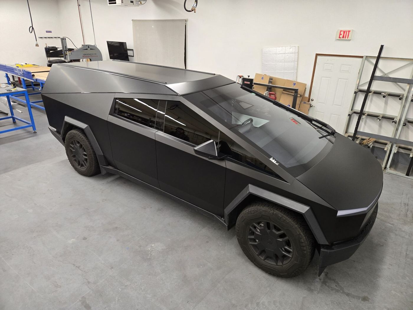 A matte black Cybertruck and matte black cap inside the aerospace shop where we built them