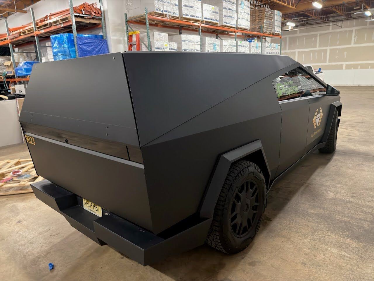 A matte black cap installed on a customer truck, staged in a warehouse before delivery