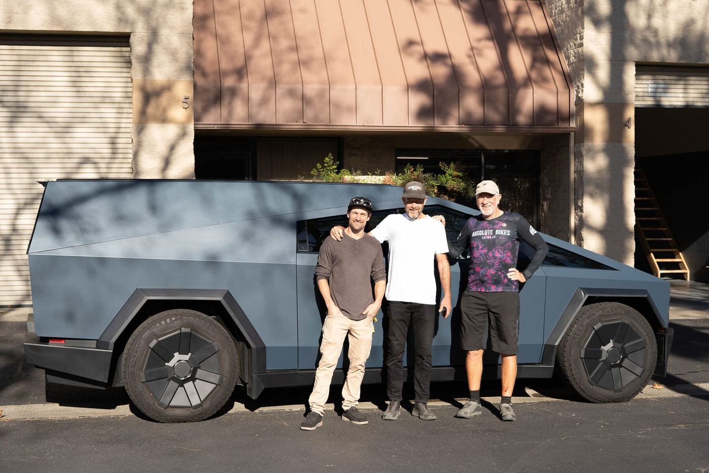 Three of us standing in front of a matte blue Cybertruck fitted with the cap, outside the San Luis Obispo shop