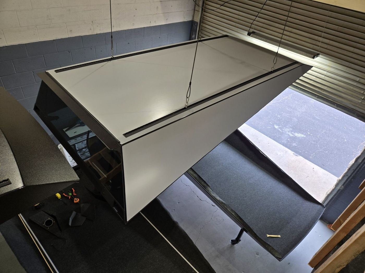 Overhead view of a finished cap hung from the shop ceiling with both side hatches open