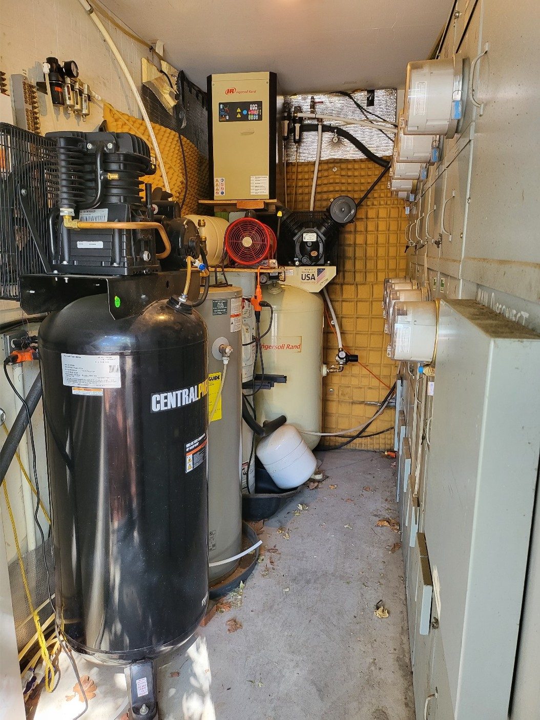 The compressor room, air compressors and dryer on one wall with the electrical disconnects opposite