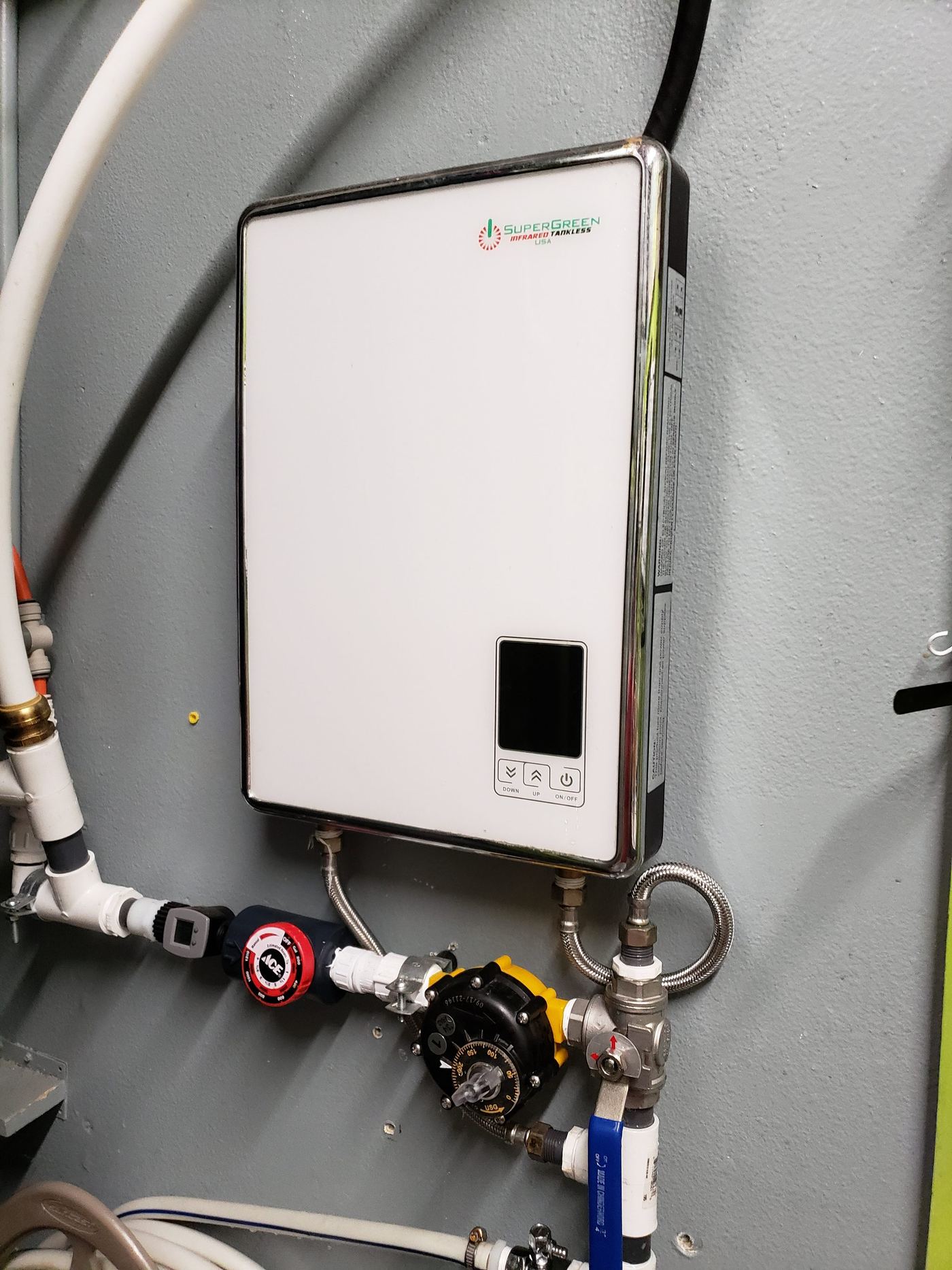 One of the tankless water heaters, plumbed in with its mixing valve and shutoffs