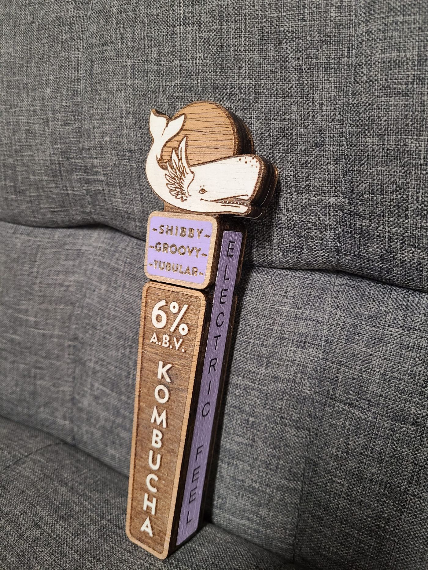 A tap handle for the 'Electric Feel' flavor reading Shibby, Groovy, Tubular at 6% ABV