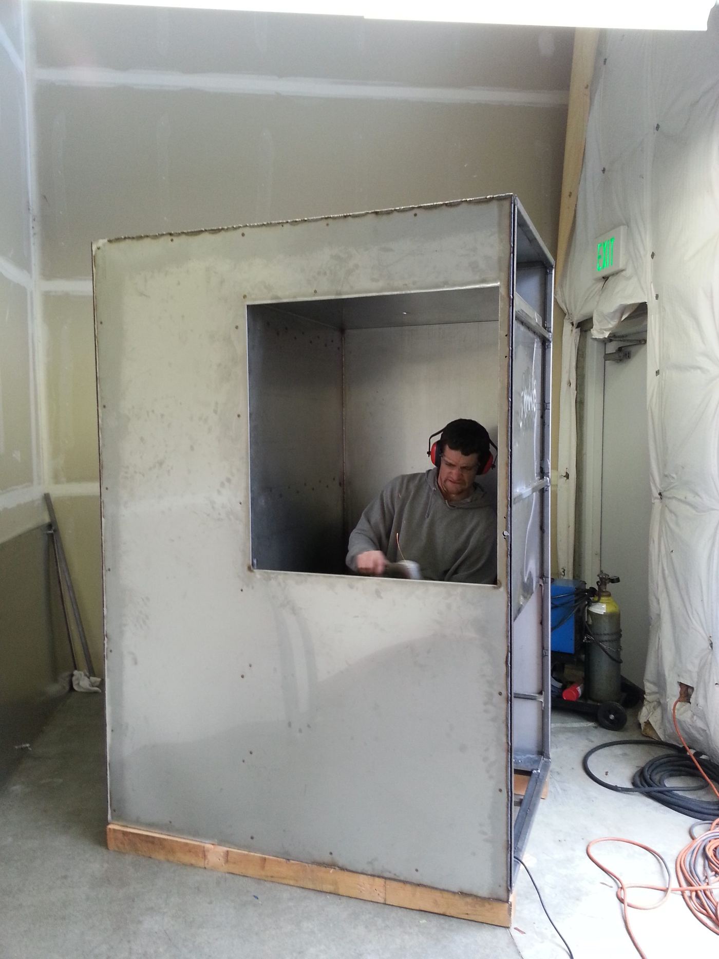 Fabricating the enclosure frame, cutting an access window into the mesh and sheet metal panel