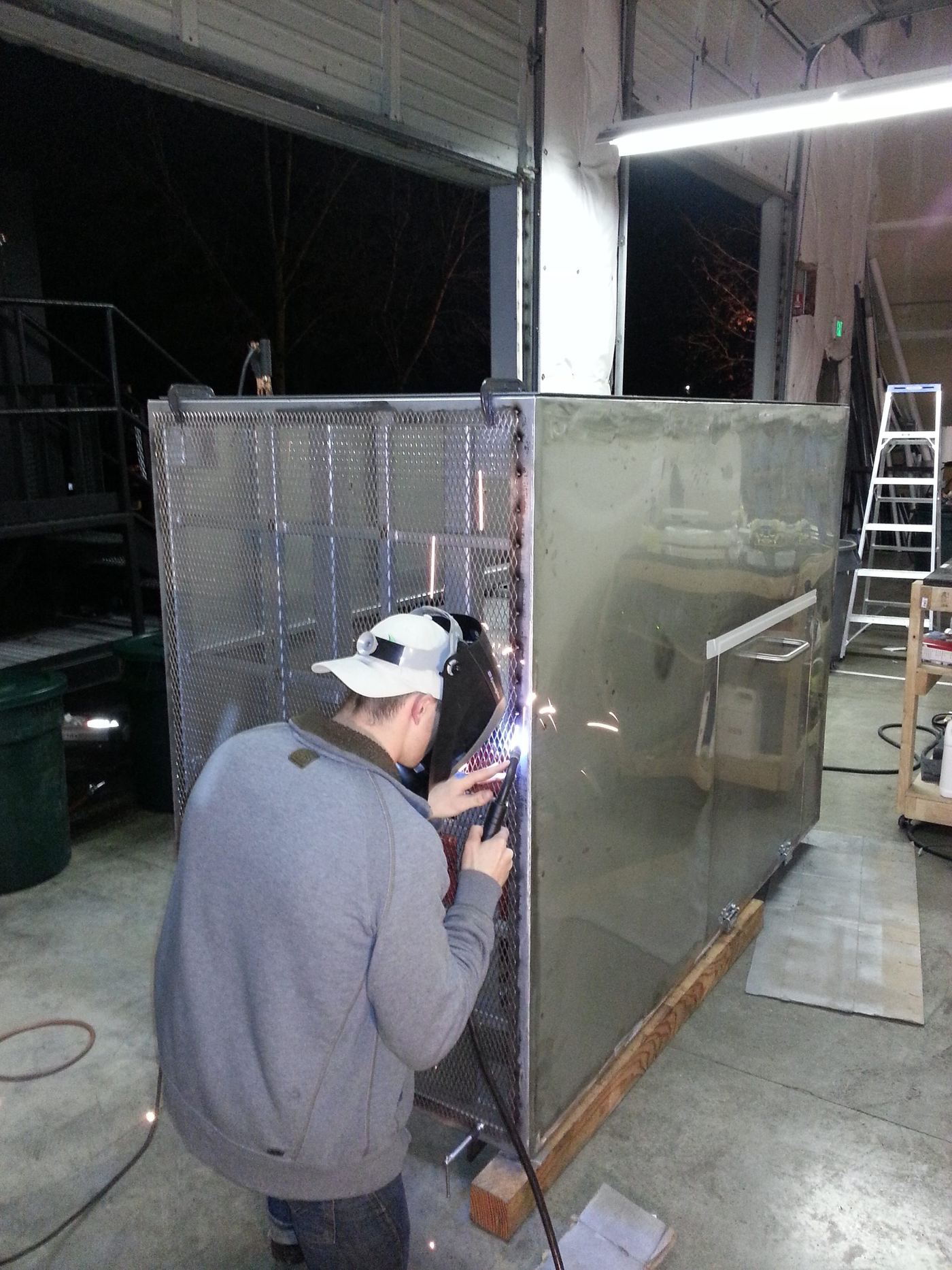 Night welding on the stainless enclosure seams in the shop