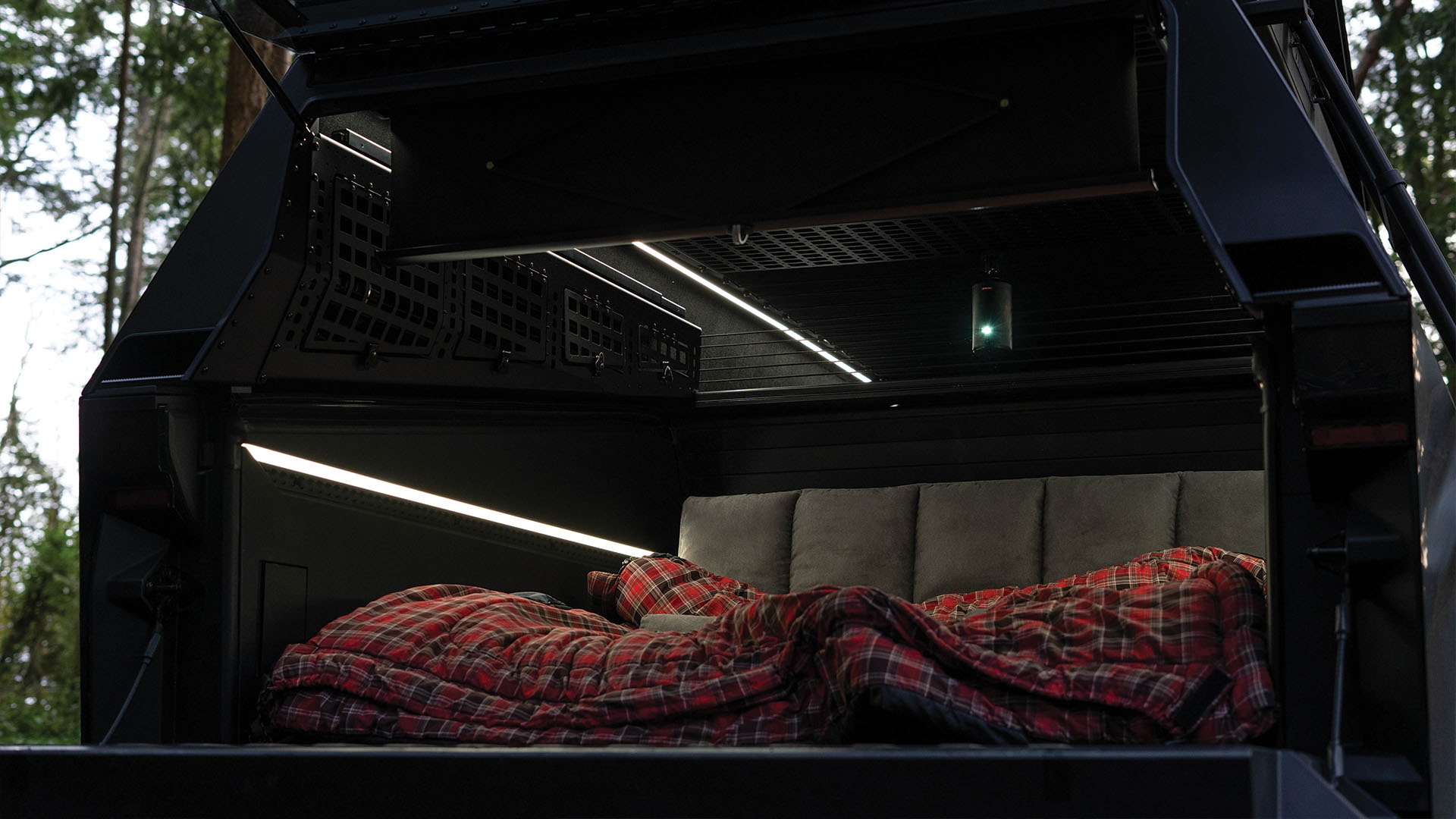 Camping in the back of the truck cap with projector playing on screen